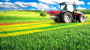 Field with a tractor in, blue sky